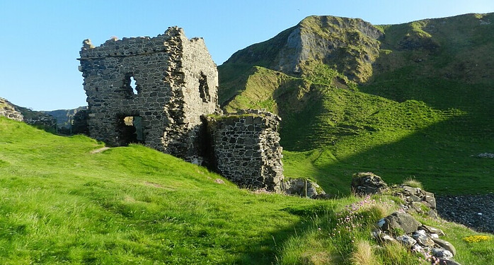 majestic castle nestled against rolling Irish hills under a dramatic sky.